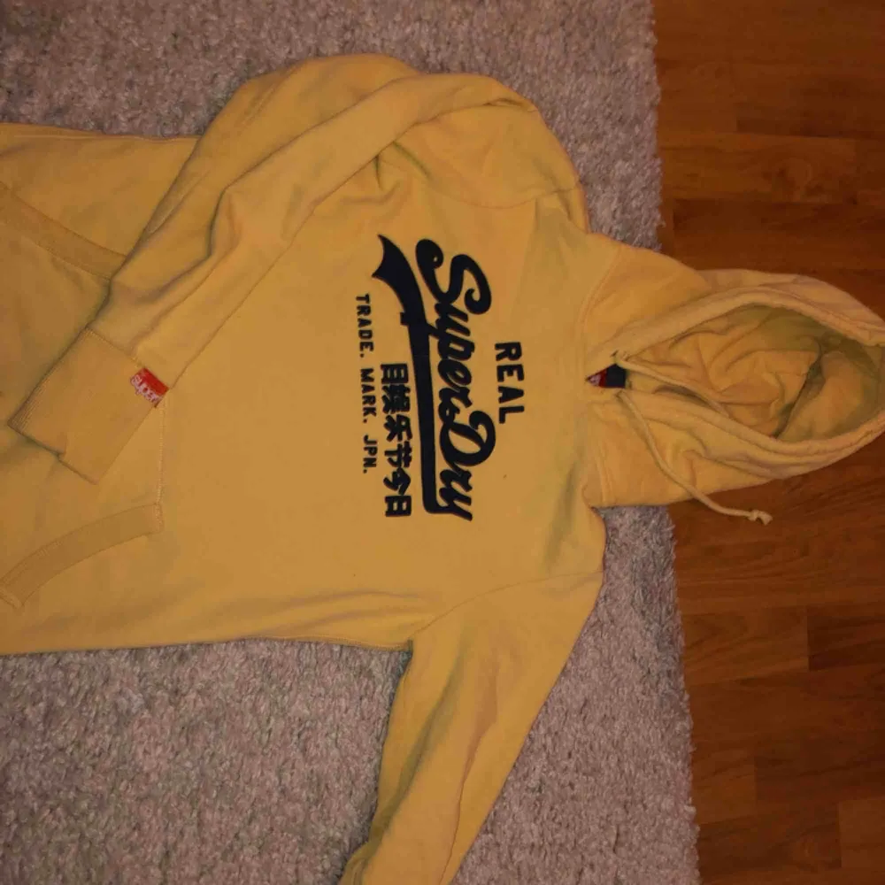 Superdry hoodie i fett cool gul färg, även om den är använd så är den fortfarande varm och härlig och säljs bara för 200kr !!!. Hoodies.