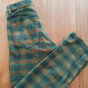  - Grön-Rutiga "Rocky jeans". Tyvärr noppriga men annars i fint skick. Storlek xs.  Frakt tillkommer.