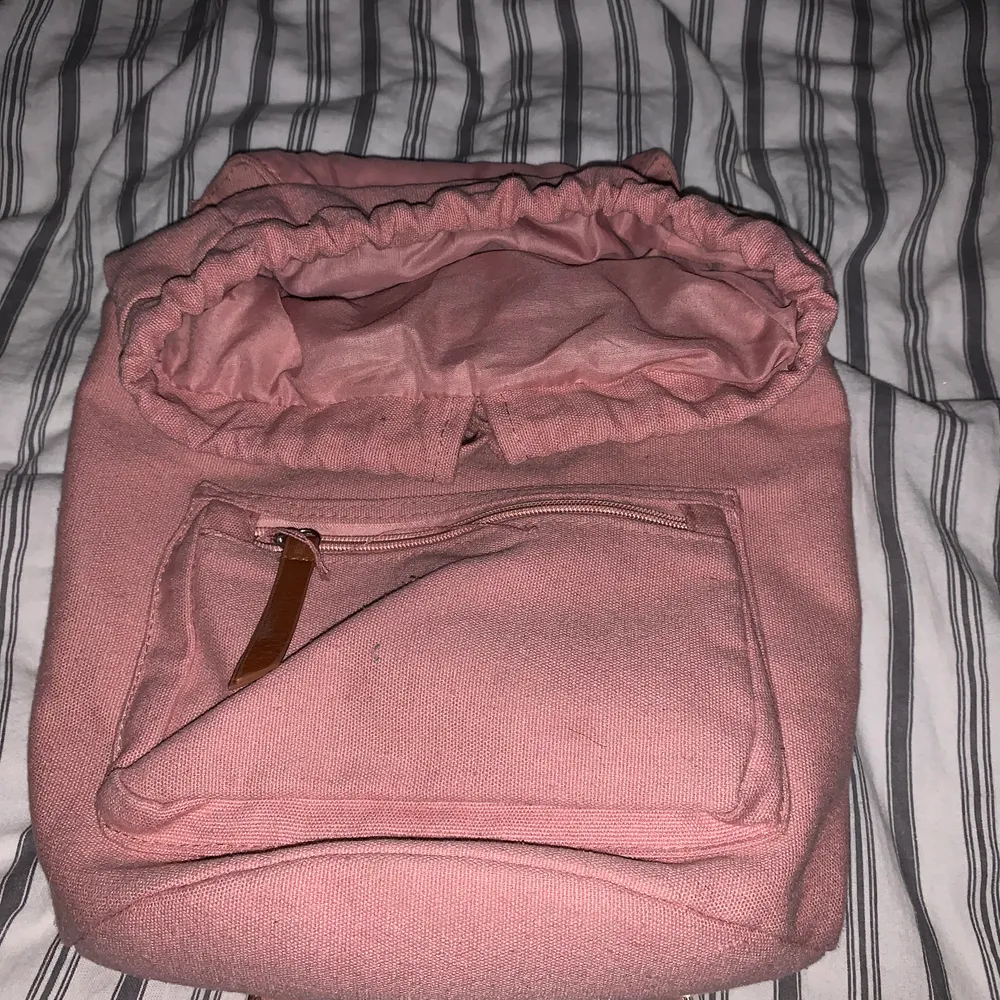 En rosa väska med ett ytter fack och ett inner fack det får plats mycket I den . Väskor.