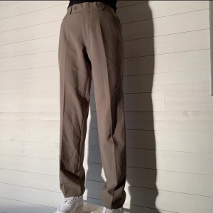 Kostymbyxor - Storlek: W33 L34  Midjemått: 92 cm  Innerbensmått: 86 cm   Färg: Brun/Grå Märke: Dressmann
