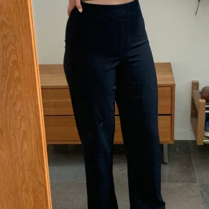 Kostym/tygbyxor från Bikbok i storlek 38 - Svarta kostymliknande byxor i ett lite tunnare tyg från Bikbok(modellen heter Adrienne Wide leg Trousers) Kostymbyxdetalj frampå. Är verkligen superfina men säljer dem då de är för korta i benen för mig (är 172) Pris 175kr+frakt 