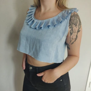 Blue Grill Top - En blå croppad volangtop i storlek M-L. ♻️ Fraktkostnad på 22kr tillkommer. ✨