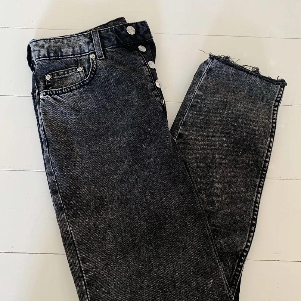 Säljer mina momjeans från H&M. Väldigt mörkgråa så man kan nästan säga svarta, dock lite stonewashed så inte helt svarta. Knäpps med knappar i midjan och de är snyggt slitna nere vid ankeln. Säljer för 150 kr!🤍. Jeans & Byxor.