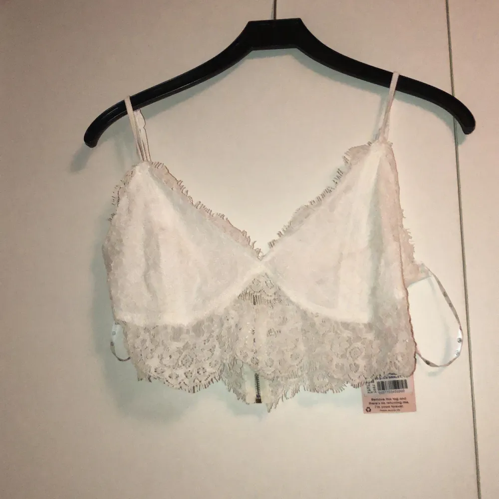 Oanvänd vit spets bralette från missguided. I sin originalpåse. Tyvärr för tunna band för min smak, därav säljes. Otroligt fin i modellen med spets undertill & dragkedja baktill. Strl 42. Toppar.