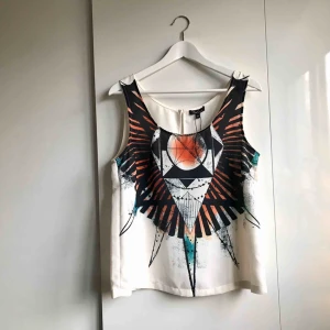 Topp - > OANVÄND <   Ett oanvänt vitt linne med tryck framtill. Vit baksida.  Nypris 299kr säljer för 50kr   Köparen står för portokostnad. 