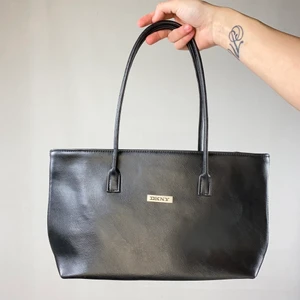 DKNY Väska  - En superfin minimalistisk axelväska från DKNY. Vet ej om den är äkta men tror nog det. I fint skick! Bredden är 36cm och höjd 30cm. SafePay knappen är aktiverad så det går att köpa direkt utan att behöva meddela! Tar annars swish! Använder helst Safepay d