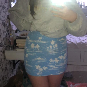 Kort kjol - Kort kjol från H&M, blå med vita palmer och vita sträck. Använd 1 gång. Jag är 165 cm lång och den är väldigt kort på mig. Storlek 36. Frakt 45kr