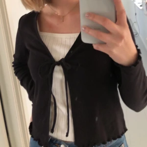 Topp med knyte - Säljer denna fina koftan från H&M som har små detaljer längst ner och på ärmarna (se sista bilden). Koftan är i bra skick och som ny, säljer den då den tyvärr inte kommer till användning.✨🤍