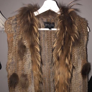  Pälsväst - Supersnygg pälsväst med fransar nertill från Hollies. Köpte för runt 1300kr på rea från Salt (märke Hollies Stockholm). Är använd runt 3-4 gånger. Storlek S/M.