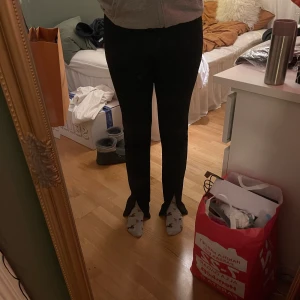 Kostymbyxor med slits - Ett par snygga svarta kostymbyxor med slits på framsidan från zara (det finns en dragkedja på framsidan så att man kan justera storleken på slitsen). Säljer pga att dem nt är min stil längre:(❤️