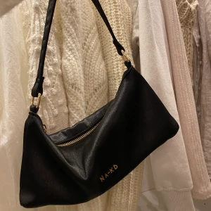 Svart baguette väska - Jag säljer nu min svarta baguette väska från nakd. Den är använd några fåtal gånger och det finns inga slitningar😊