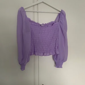 Lila topp - Stretchig lila topp från H&M, aldrig använd och prislapp sitter kvar. Storlek M. (Köparen står för frakt)