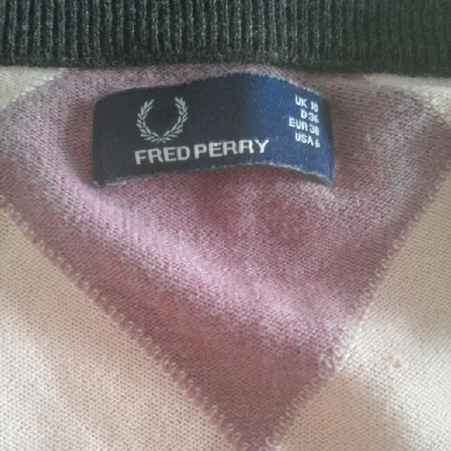 Jättefin Fred Perry finstickad tröja med rutmönster. Är i lila, rosa, svart färg. Tröjan är inköpt för ett år sedan och har använts sparsamt. Mycket fint skick och har inga skav eller slitningar. Storlek 36.. Stickat.