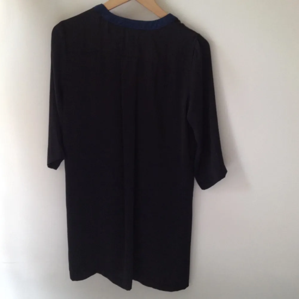 Margit Brant, long black blouse with a petrol collar . Blusar.