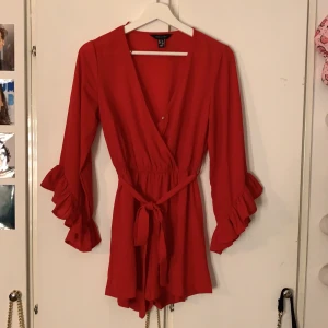 Röd dress - Säljer denna dress, är osäker var den är ifrån. Som ni ser på bild tre så har knappen lossnat en gång men har gått att sy fast igen, men väldigt fin annars. Köparen står för frakten💛