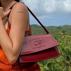 Vinröd axelremsväska - Urgullig liten axelremsväska 🥺 köpt i Filippinerna på marknad såååå köp om du vill ha en one of a kind-väska!!!! 