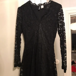  - Svart klänning i spets med lång ärm, fodrad förutom armarna, v-ringad med spetskant i ringningen, tight upptill och klockad kjol. Divided h&m   Mycket fint skick! Använd två ggr 