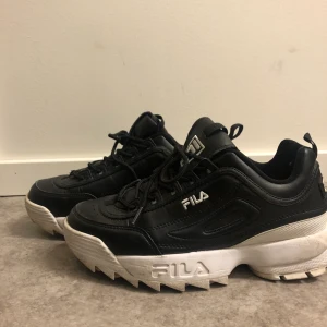 Svarta Fila skor  - Ett par snygga svarta Fila skor som kan piffa upp en outfit på direkten. Finns en brist på vänstra skon men syns knappt ☺️. I storlek 39 1/2. Frakt tillkommer ✨✨