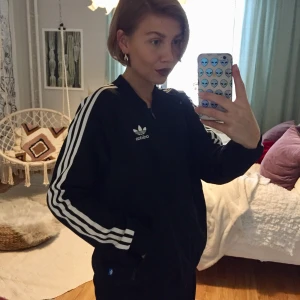 Adidaströja - Klassisk Adidaströja med vit logga på ryggen. Strl 42. Sitter snyggt och ledigt.