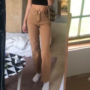 Bruna/beiga jeans weekday  - Bruna/beiga jeans från weekday i den populära modellen ”row”. Knappt använda och i bra skick! Sitter som en smäck och sköna! Storlek W 26 L 32. Om många är interesserade blir det budgivning💫