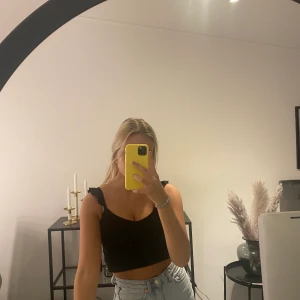 Topp - Super fin svart topp från bikbok! Den har en volang som axelband vilket gör så så mycket! Storlek xs och säljer för 60 kr + frakt!