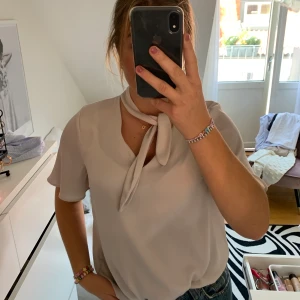 Supersnygg blus - En super classy blus ifrån H&M i en jättefin beige/grå färg med knyte vid halsen som man antingen kan knyta eller ej.💝😋🤠  Hör av dig med eventuella frågor! Köparen står för fraktkostnader💖 