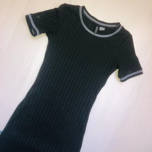 Tight ribbad klänning - Supersnygg tight ribbad klänning från H&M med snygga vita ränder. Den går till ungefär mitten på låren beroende på din längd. Nästan helt oanvänd! 