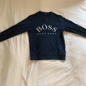 Hugo boss tröja, strl S - Marin blå Hugo boss tröja, använt väldigt få gånger alltså är den i väldigt bra skick. Säljer den för den inte längre är i min stil men i övrigt väldigt skön och snygg vardags tröja