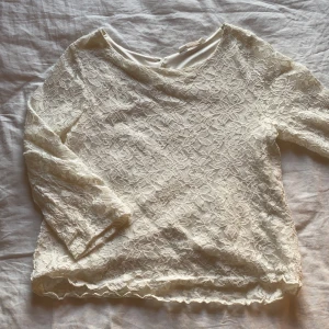 H&M spetsblus strlk 158  - Tröjan är i strlk 158 men passar bra på XS/S. Ärmarna går ungefär till armbågarna. Den är i spets men har ett undertyg under hela tröjan förutom armarna. Relativt nyskick och endast använd ett antal gånger. 