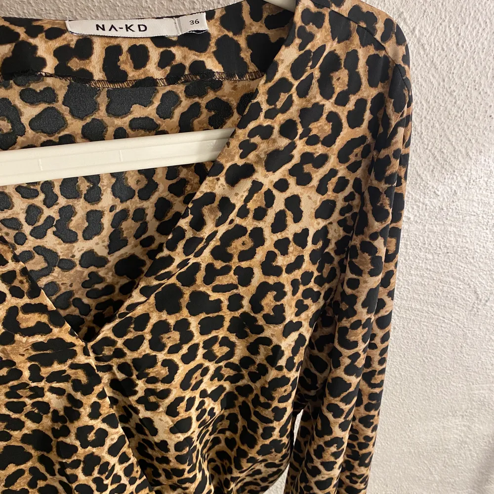 Blus med leopardtryck i storlek 36. Den har en v-ringning vid brösten och långa ärmar med fransiga manschetter vid ändarna. Använd fåtal gånger. Ordinarie pris: 249kr🌸 . Blusar.