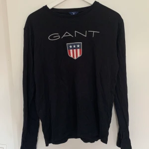 Svart långärmad GANT tröja - Säljer denna svarta långärmade GANT tröja. Knappt använd. Storlek 176 men passar mig med M. Ny pris 400, mitt pris 200. Billigare vid snabb affär.