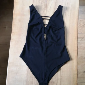 Svart Body strl S - Hejhej, jag säljer denna body då det inte är min stil. Den har djup urringning och öppen rygg med banden korsade. Mycket bra skick då jag aldrig använt den. Köpt på bikbok för ca 1 år sen, original pris 199kr. Köparen står för frakt.