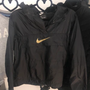 Nike Vindjacka - Skit snygg vindjacka som inte kommer till användning längre. Den har en liten ficka på magen och två på sidorna. Man kan även dra in den i midjan, perfekt sommar jacka! Köpt för 699kr på nike. Frakt tillkommer!💓
