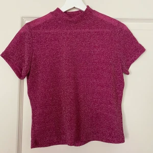 Glittrig topp  - Rosa glittrig topp från Monki strl M. Skulle säga att den är liten i storlek så passar absolut S. Fraktkostnad tillkommer // kan mötas upp runt Karlshamn. 