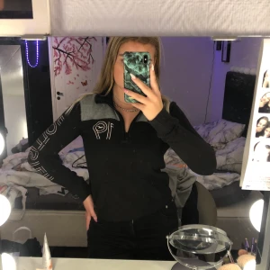 Hollister zipup tröja - Svart och grå zipup tröja från hollister med lite text och siffror som detalj, väldigt skön och så men har tyvärr blivit för tajt i armarna för mig :( 250kr inklusive frakt