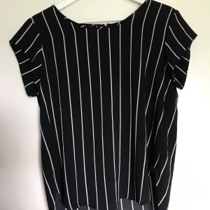 Blus - Svart/vit randig blus med dragkedja på baksidan. köparen står för frakten! 
