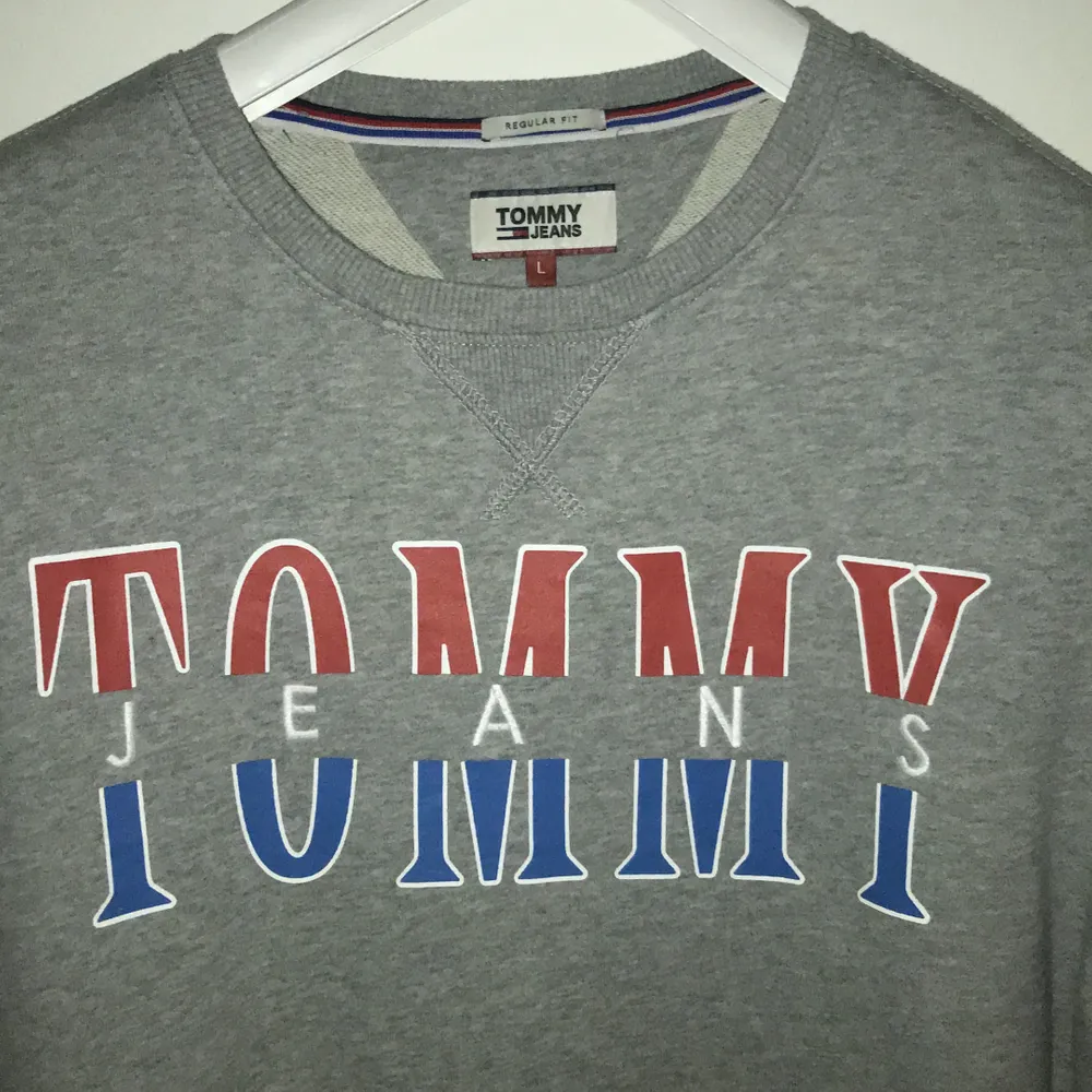 Grå sweatshirt från Tommy Jeans. Storlek L använd fåtal gånger. Vid leverans beror det på vad det kostar att skicka😇. Hoodies.