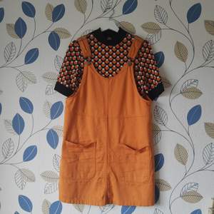Orange hängselklänning från Monki i storlek S. Går ner en bit på låret på mig som är 175 cm lång. Färgen på sista bilden är mest sann. Man kan även köpa till tröjan för 100 kr, som även den är från Monki och i storlek S! 🧡 frakt tillkommer ~