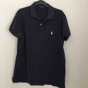  - T-shirt från Ralph Lauren. I sliten blå färg.