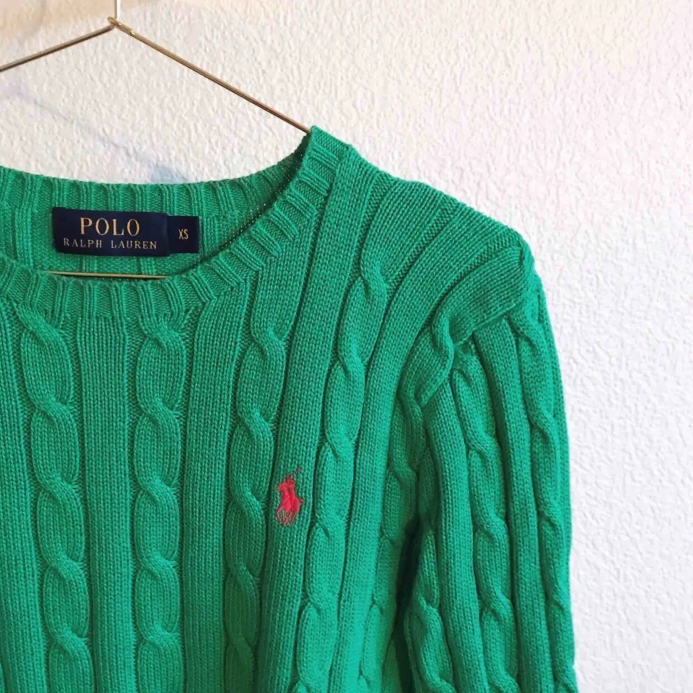 Kabelstickad tröja från POLO RALPH LAUREN. Grön med röd logga, rundad halsringning. Mycket fint skick. Kommer från ett djur- & rökfritt hem. . Tröjor & Koftor.