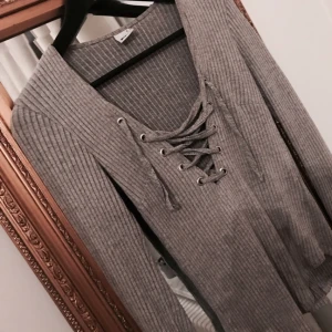  - Grå tröja med snörning. Från ginatricot, andvänd fåtal gånger. Storlek s, passar även m.