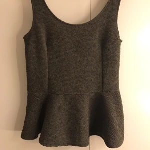  - Söt topp från mango i militärgrönt. Djup i ryggen och med volang. Lite ribbat material och sparsamt använd. 