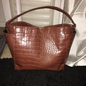  - Brun väska från BikBok med fack på sidorna