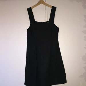  - Klassisk kostymaktig klänning i mörkgrått. Materialet ganska grovt, fint tyg. Strl ca XS.