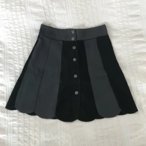  - En a-linjeformad kjol i skinn som är köpt i vintagebutik i Paris. Den stängs med tryckknappar framtill, storlek w24/25 eller XS. Ihopsydd med olika typer av läder och mocka, riktigt fin i formen. Köparen står för frakt, betalning via bankkonto eller swish. Upphämtning i Linköping går bra