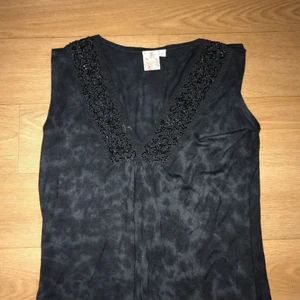  - Ett fint fest linne med fina detaljer längst V-ringningen.