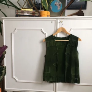  - Mockaväst med fransar i härlig grön färg. Köpt på second hand. Köparen står för frakten.