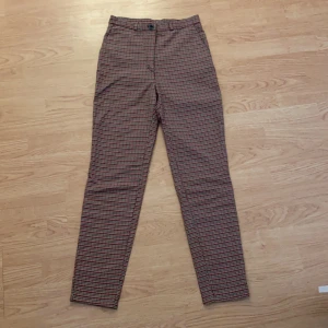 Rutiga byxor - Säljer mina supersköna byxor från Monki! Säljer pga av att jag har ett par likadana fast svartrutigt och använder dom mer. Älskar verkligen passformen på dessa byxorna och att dom är högmidjade🥰 Strl 32!! Tar endast Swish, kan mötas upp i centrala Malmö!
