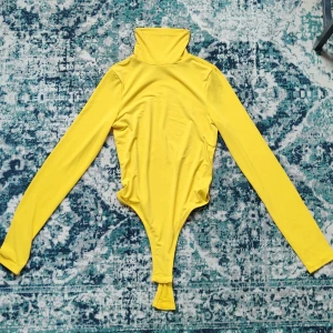 NA-KD body - As cool gul Body ifrån NA-KD, nästan aldrig använd. Storlek S, väldigt stretchig i materialet och materialet i sig är extremt skönt att ha på sig. Bodyn har en string rumpa, vilket gör att den inte syns! Fraktar gärna, köpare står för frakt isf☺️