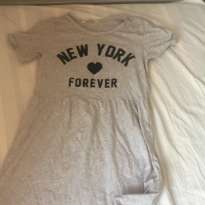 Grå barn klänging - Ljus grå barnklänning men svart glittrig text. Använd 1 gång. Bra sick